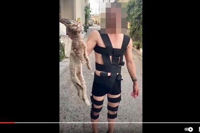 首根っこを掴む若い男性