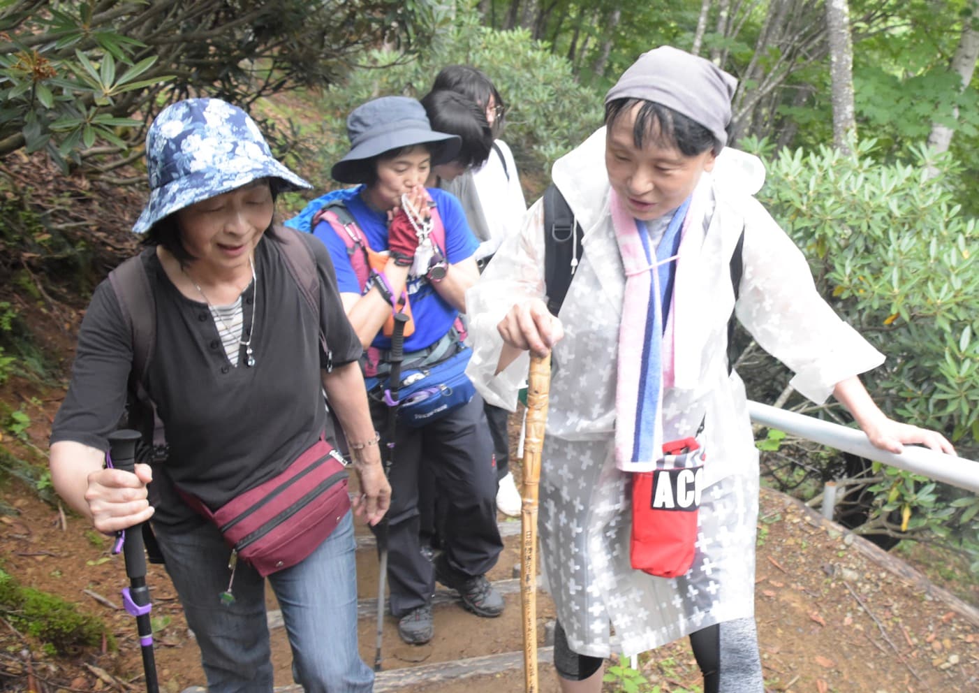 日航ジャンボ機事故で友人を亡くした女性（右）と話しながら登る安部さん（左）ら（弁護士ドットコムニュース撮影）